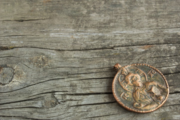 Fototapeta na wymiar old copper coin pendant with the symbol of saint and cross