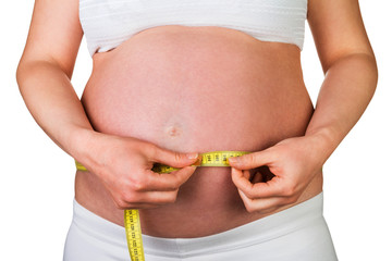 Pregnant woman measures tummy yellow centimeter isolated on white.