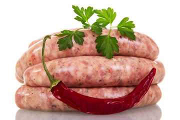 Uncooked sausage, red pepper and parsley isolated on white.