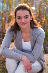 Teen sitting down looking up outdoors portrait.