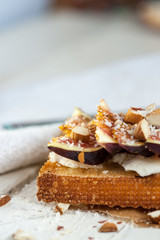 Bruschetta with goat cheese and figs on list of parchment