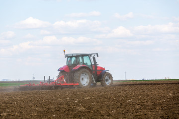 Farmer in tractor preparing land with seedbed cultivator