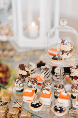 Delicious cakes stand on tired glass tray 