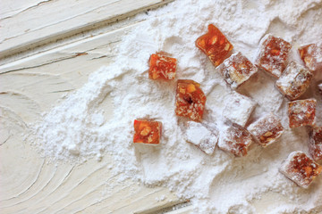 Pieces of quince jam in sugar powder.