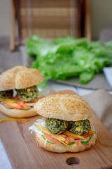 Vegetarian fast food - falafel burger on wooden board.