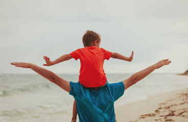Obraz premium happy father and little son play on sky at beach