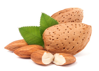 almonds in their skins and peeled with leaf isolated on white background