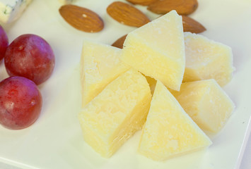 Parmesan cheese with grape on board