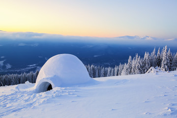 Naklejka premium Big round igloo stands on mountains.