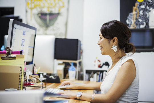 Design Studio. A woman sitting at a desk using a computer. 
