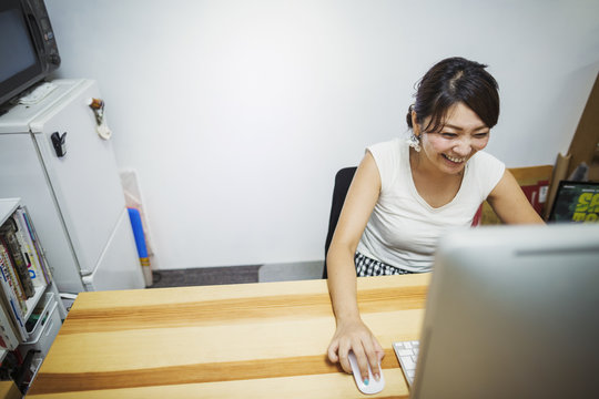Design Studio. A woman working at a desk using a mouse and computer. 