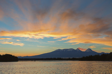 Beautiful sunrise over volcanoes Kluchevskaya group with reflection in the river Kamchatka.