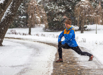 Fototapeta na wymiar Young sport woman doing exercises during winter training outside in cold snow weather 
