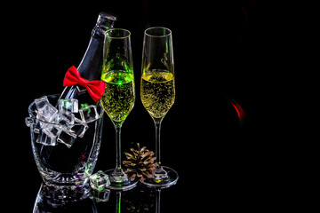 Bottle champagne in ice bucket with wineglasses and cone