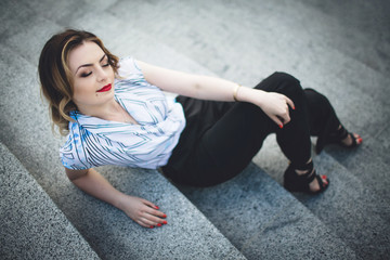 perfect woman sitting on stairs and looking at photographer