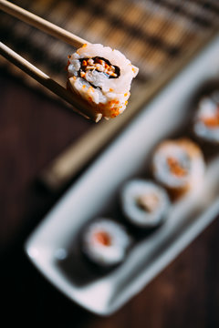 Sushi maki rolls and sashimi on a wooden background