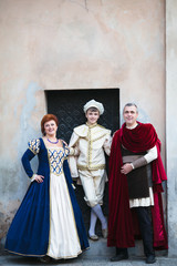 Fototapeta na wymiar Beautiful family in medieval clothes posing in old town