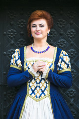 Fototapeta premium Beautiful woman in medieval dress in the old town
