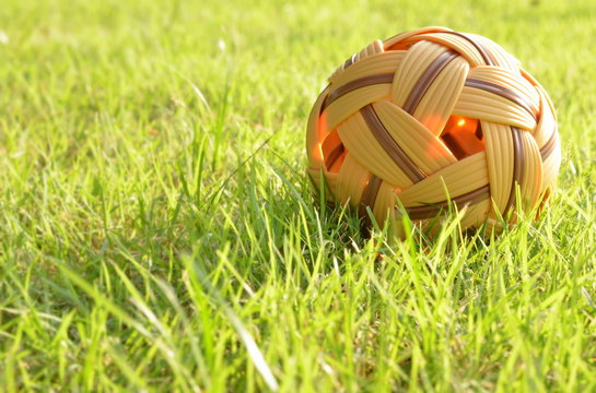 Rattan ball on green grass in evening day,outdoor activities.