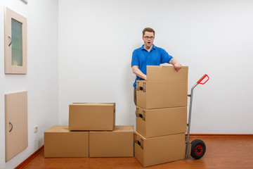 Mann packt Kartons auf eine Sackkarre