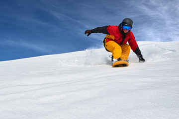 Fototapeta na wymiar snowboarder very quickly goes down slope freerider