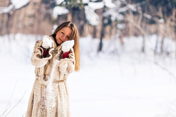 Winter portrait of young beautiful woman wearing fur coat. Snow winter beauty fashion concept.