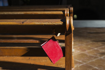 Bible hanging on a wooden bench inside a church