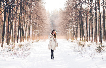 Fototapeta na wymiar Girl walking in snow. Winter, cold and people concept