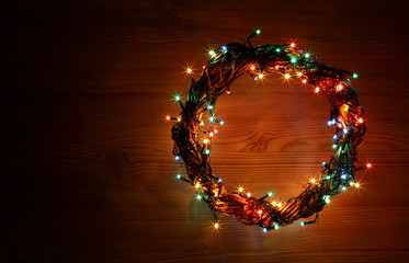 Winter holidays template card with copyspace on dark old wooden background. Wreath and garlands of...