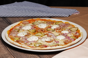 Pizza with bacon and onion on wooden table