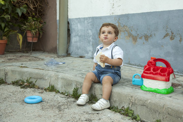 Naklejka premium Full shot portrait cute baby boy having a snack