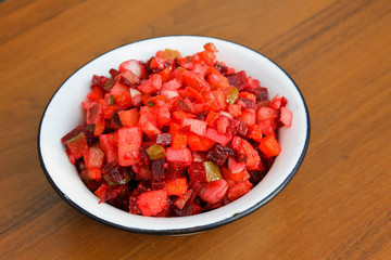 Russian beet salad vinaigrette in rustic bowl on wooden table