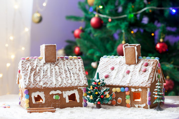 Two gingerbread houses, tree and people sitting on a bench, wint