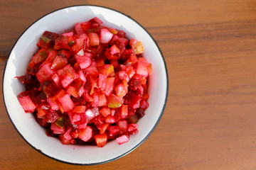 Russian beet salad vinaigrette in rustic bowl on wooden table