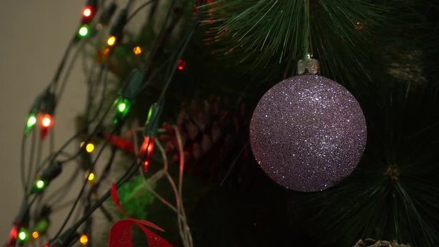 shiny Christmas ball on a Christmas tree with blinking garlands