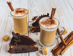 Chocolate cake, two cups of cappuccino and spices