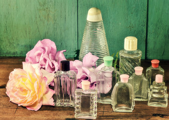 Roses and vintage glass bottles in vintage tone arrangement.