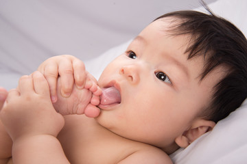 Portrait of cute Little asian boy 6 months old on the white bed