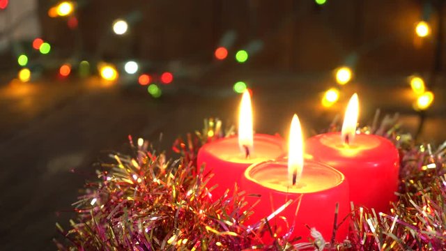 burning Christmas candles. Blurred background with Christmas garland