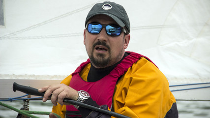 Man in the Finn Class sailboat participates in one of the match race regattas
