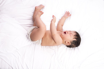 Portrait of cute Little asian boy 6 months old on the white bed