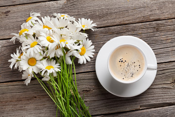 Chamomile flowers bouquet and coffee cup