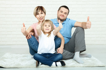 happy family mother, father and two children playing and cuddling at home on floor