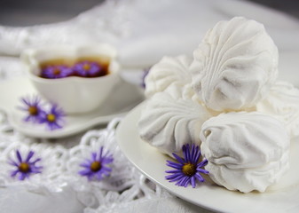 Fototapeta na wymiar зефир белый с цветами и чашкой чая