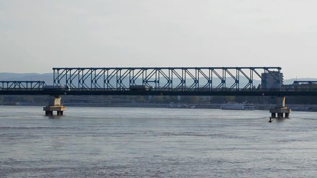 Cars, trucks and lorries crossing Danube river at bridge; 