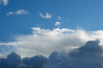 Naklejka na ściany i meble Evening clouds on the background of the blue sky.