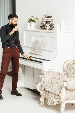 Handsome man singing near piano