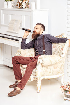 Handsome man singing in armchair