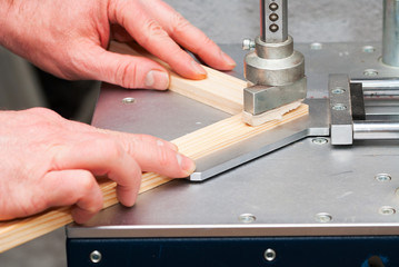 Craftsman working on frame in frame shop. Professional framer hand holding frame angle. Top view. Copy space