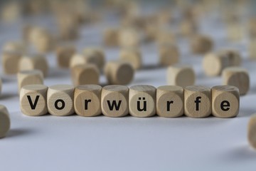 Fototapeta premium Vorwürfe - Holzwürfel mit Buchstaben